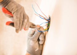 man in glovers using pliers working with electrical wires full home installation annapolis electrician